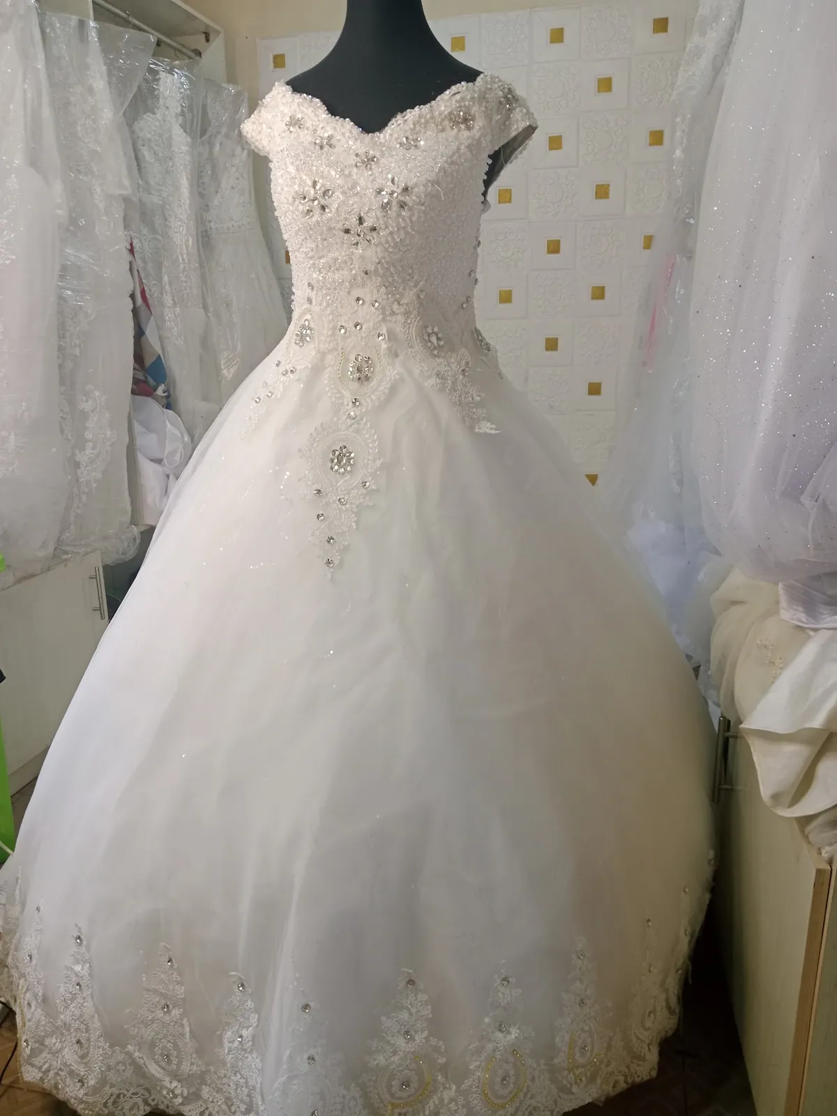 Ivory ball gown with lace appliqué bodice on display