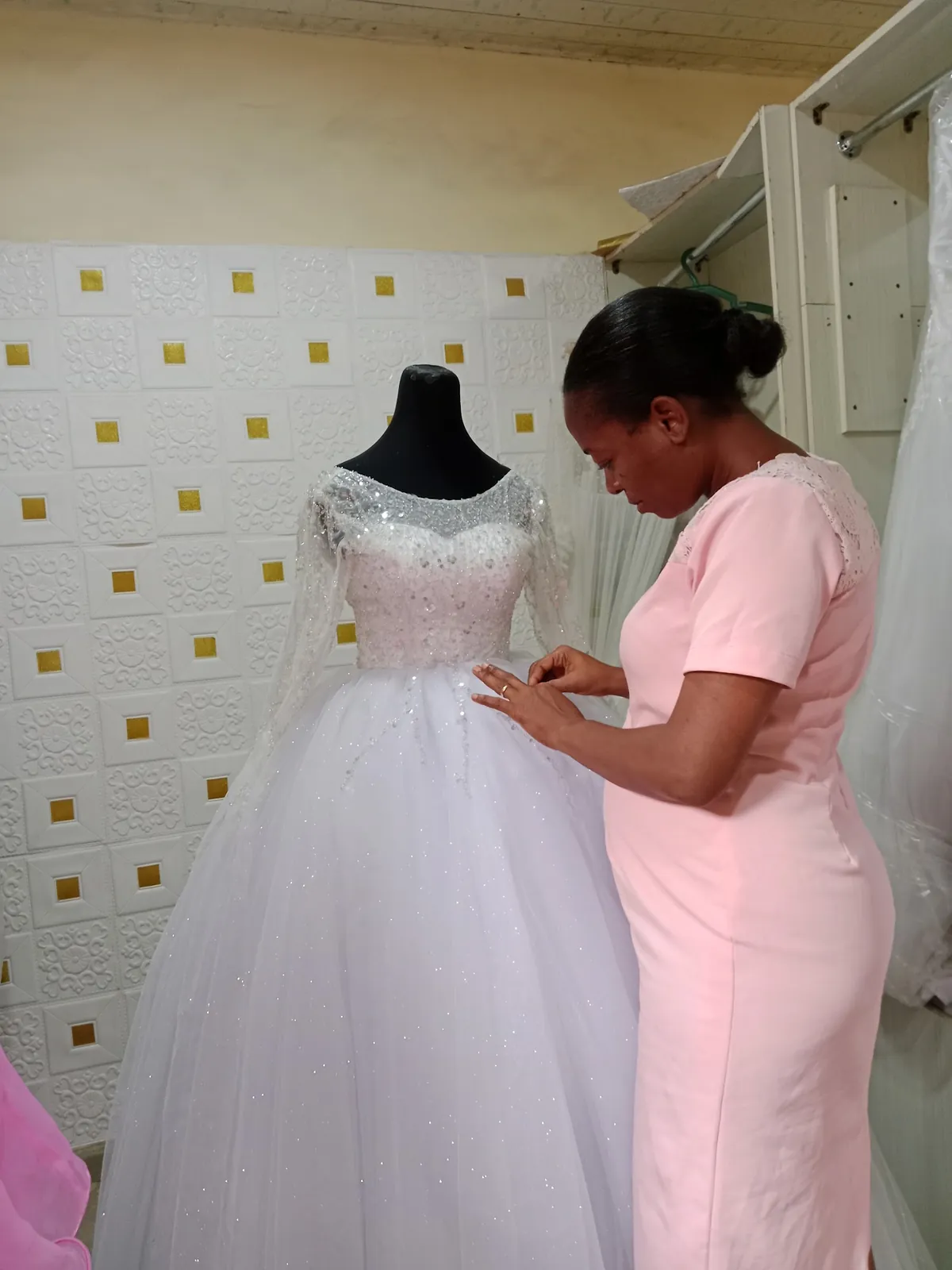 Final adjustments on a bridal gown in the studio