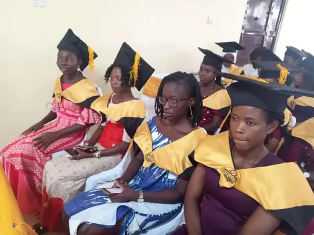 Graduates seated in caps and gold stoles